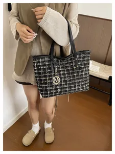 Gedetailleerd overzicht van stijlvolle tweed ruitjes tote tas met handvatten en metalen bedel.