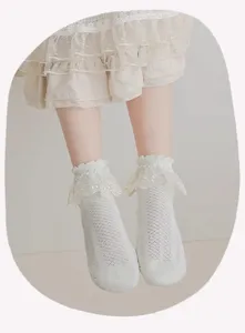 Gedetailleerde close-up van witte sokken met kanten volants en ademend mesh.