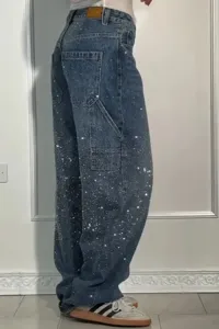 Detail view of women's rhinestone denim jeans, featuring sparkling glitter straight leg fit.