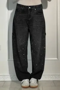 Detailed view of black rhinestone denim pants featuring sparkling rhinestone details and straight fit.