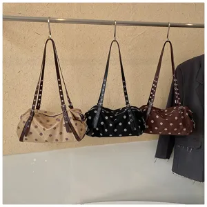 Detailed view of the trendy polka dot underarm shoulder bag with stylish metal grommet straps.
