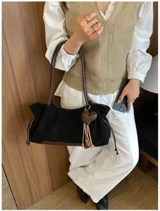 Casual vintage black shoulder bag with brown straps and heart charm detail for daily commuting.