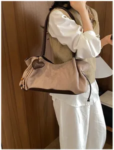 Vintage brown shoulder bag for women, retro tote handbag with heart pendant and stylish tassels.