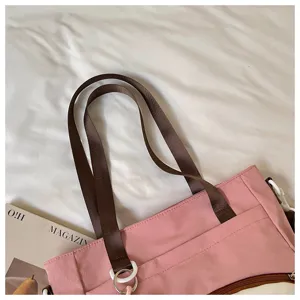 Vue détail de cabas en toile rose, sac fourre-tout décontracté avec lanières marron et zip.