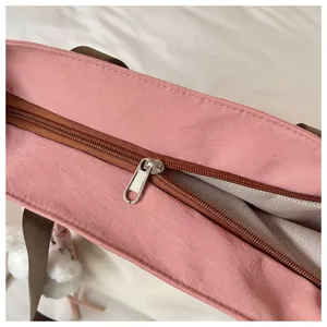 Vue détaillée du sac cabas rose pour étudiant, tissu durable et fermeture éclair marron.