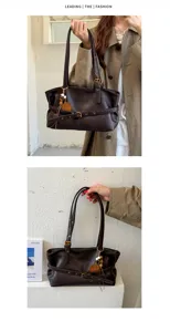 Detail shot of the vintage brown shoulder tote bag with decorative belt and bead charm.