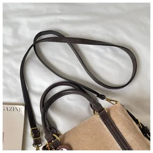 Detailed view of women's retro brown and beige suede tote crossbody bag for autumn.