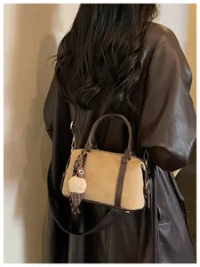 Detailed view of the vintage suede shoulder bag with brown leather trim and cute ice cream charm.