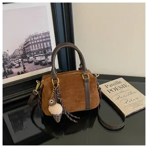 Chic brown suede boston handbag for women, retro crossbody shoulder bag with cute charm.
