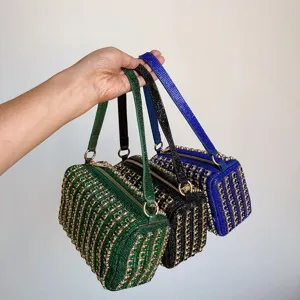 Close-up detail showing sparkling rhinestones and metal chains on luxury box handbags.
