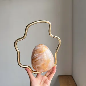 Detail shot of French niche irregular evening bag, unique wavy metal handle, gradient design