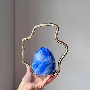 Detailed view of the luxury marble blue egg evening bag with unique gold wavy metal handle.