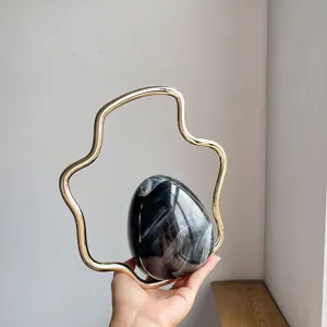 Detailed shot of the unique irregular metal handle and black gradient egg shell evening bag design.