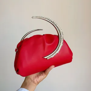 Red evening bag with a unique crescent rhinestone metal handle and soft pleated design.