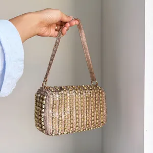 Detailed view of the luxury sparkling rhinestone beaded handbag and elegant shoulder strap.