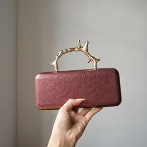 Detailed view of the luxury metal branch handle evening clutch bag showing its exquisite texture.