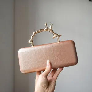 Elegant metallic branch handle clutch bag, premium rose gold textured evening purse for women.