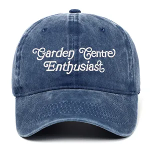 Vintage washed blue baseball cap close-up with detailed white embroidery lettering.