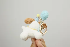 Handmade crochet dog keychain close up, cute yarn puppy bag charm detail view, soft toy accessory.