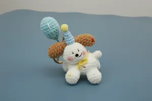 Handmade crochet puppy keychain with cute balloon and party hat design, soft yarn knit detail.
