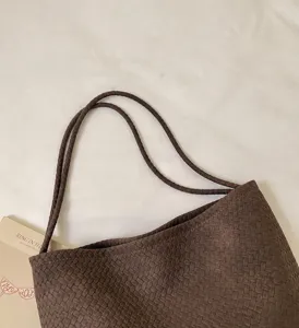 Detailansicht einer stilvollen gewebten Umhängetasche mit robusten Trägern und Vintage-Design.