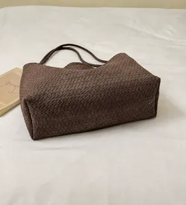 Nahaufnahme des braunen gewebten Umhängetaschen Details mit exquisiter Lederstruktur.