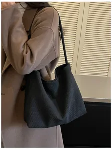 Vue de détail d'un sac à épaule tissé noir élégant, design chic pour les femmes mode.