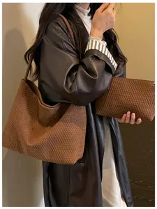 Vue detaillee du sac porte epaule en cuir tresse marron au superbe style retro moderne.
