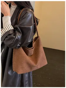 Élégant sac à bandoulière tissé marron avec texture artisanale classique pour usage quotidien.