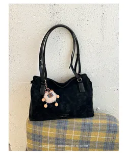 Gedetailleerd uitzicht van zwarte retro tote schoudertas, stijlvolle suèdetextuur.
