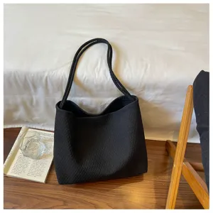 Sac porté épaule tissé noir détail montrant un beau tissu texturé et un style urbain épuré.