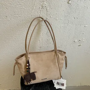 Vue detaillee du grand sac cabas en suede, elegante sac porte epaule retro pour le travail.