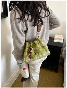 Vintage green fabric shoulder bag with boho paisley pattern, drawstring and cute bead charms.