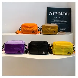Detalle de mini bolso cruzado con múltiples bolsillos que muestra varias bolsas coloridas.