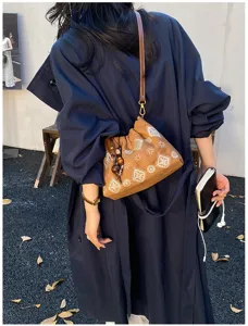 Brown retro patterned shoulder bag with bead pendant detail, chic casual crossbody style