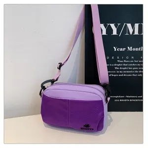 Vista detallada del bolso cruzado morado de nylon con multiples bolsillos y correa.
