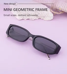 Gros plan de petites lunettes de soleil géométriques à verres noirs et branches en métal.