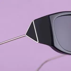 Gros plan détaillé de lunettes de soleil noires carrées avec charnière triangle en métal.
