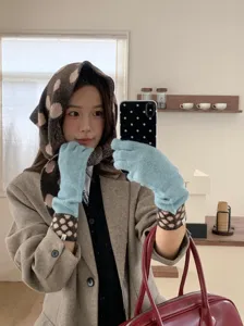 Knit polka dot triangle scarf and warm gloves set, retro winter fashion style detail shot.