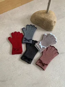 Vista detallada de guantes de punto a rayas multicolores para mujeres, accesorios de invierno.