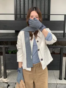 Detalle de bufanda y guantes de punto a rayas, conjunto acogedor de otoño para mujer.
