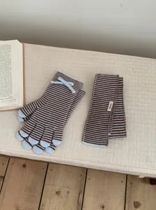Conjunto de bufanda y guantes de punto a rayas para mujer, detalle de moda de invierno.