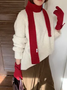 Vista detallada del conjunto de bufanda y guantes de punto rojo para un estilo invernal.
