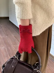 Primer plano detallado de guantes de punto a rayas rojas con un bonito lazo para invierno.
