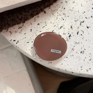 Vista dettagliata del supporto per telefono in resina epossidica marrone con testo.