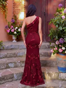 Details of burgundy one-shoulder evening dress with floral embroidery and slim fit.