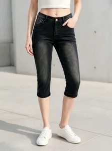 Primo piano dettagliato di pantaloni capri in denim scuro slavato da donna, vestibilità skinny.