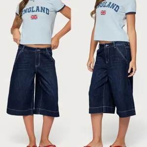 Detailed view of low-waist loose denim capris, washed fabric, casual straight fit style.