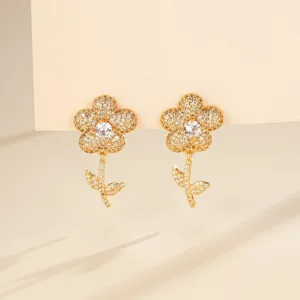 Boucles d'oreilles détaillées fleurs en zircons, pierres scintillantes et design doré élégant.