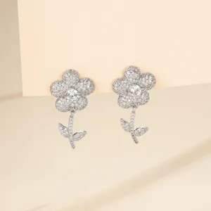 Gros plan détaillé de boucles d'oreilles fleur zircon étincelantes, texture argentée.